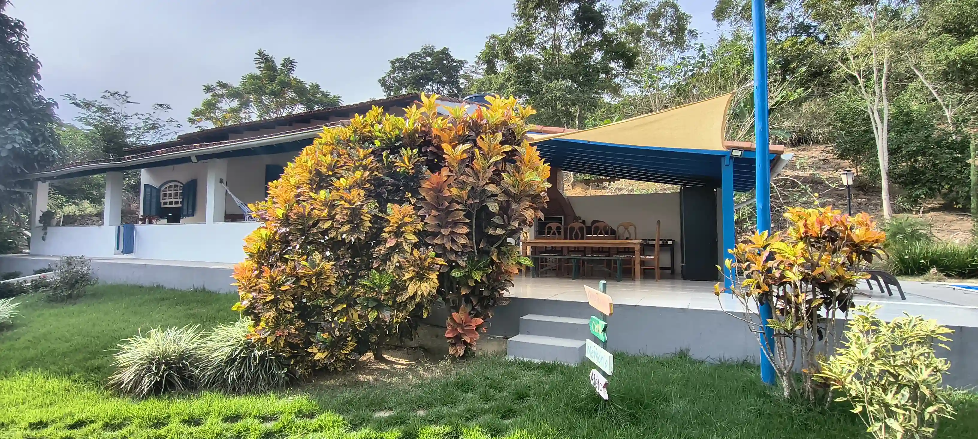Fachada frontal do casarão colonial com varanda e janelas azuis no Sítio Canto da Seriema